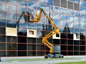 Vinç kullanarak dış cephede cam temizliği yapan personel